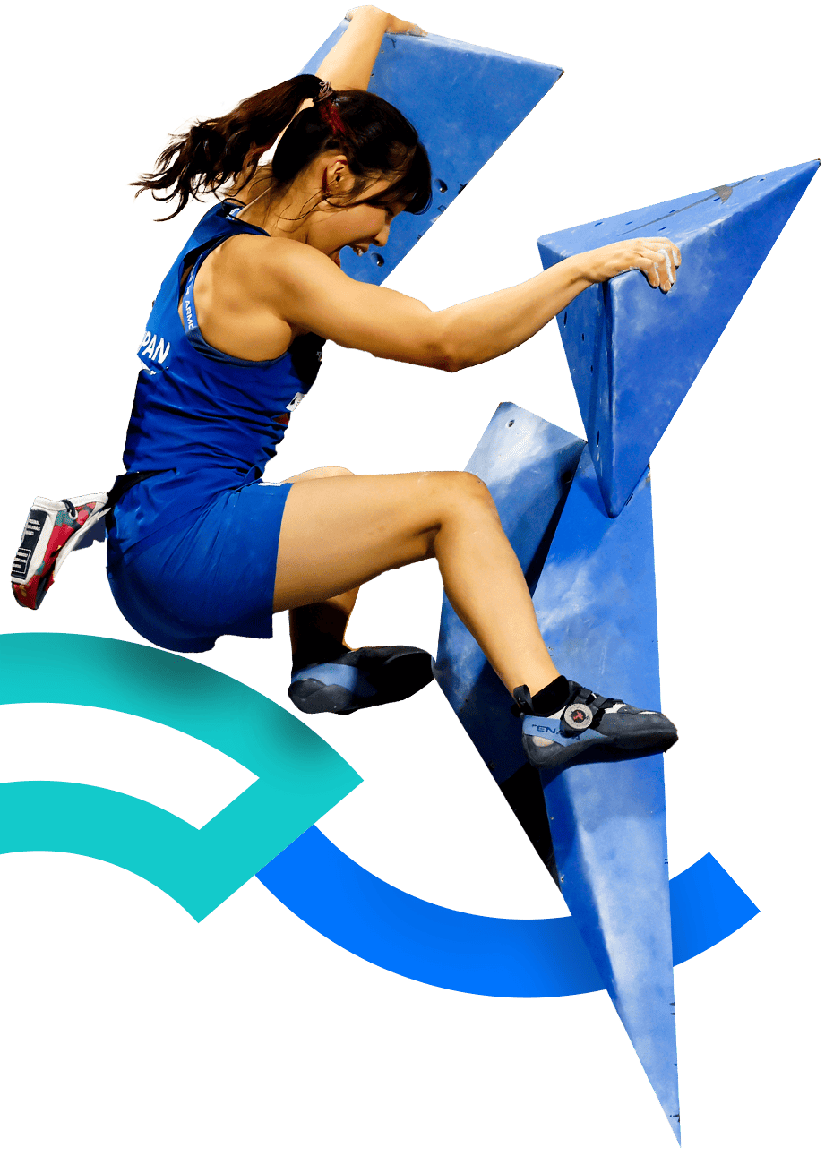 In the picture, a female climber dressed in blue can be appreciated. She is participating on a blocks wall, also blue.