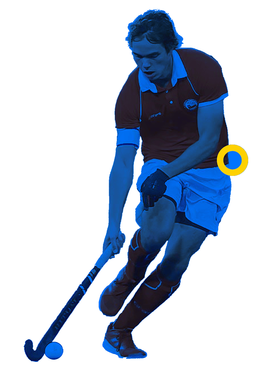 In the picture, a famale hockey player above the grass is holding the stick with both hands and hitting the ball.