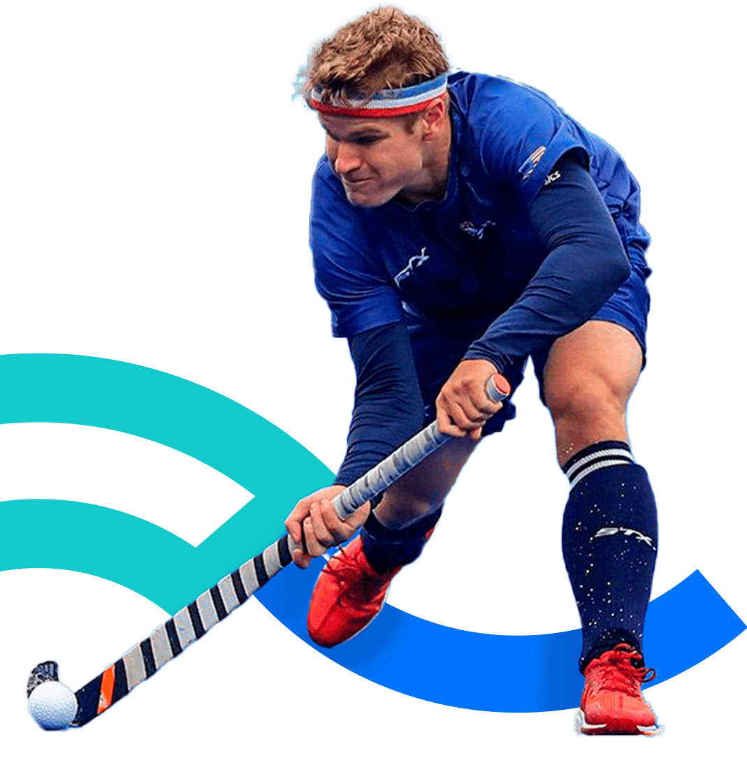 En la foto, una jugadora de hockey sostiene el stick con ambas manos mientras conduce la pelota. 
