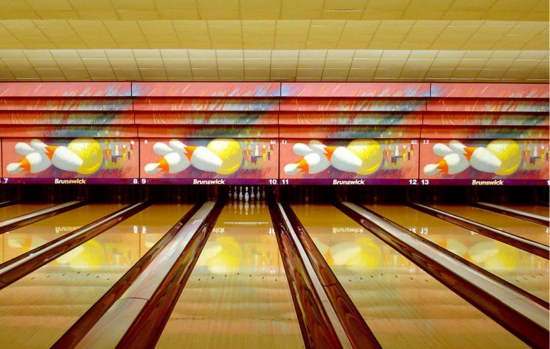 A frontal shot of the bowling lanes of La Florida can be 
                            appreciated. At the back, in lane 10 you can see the 
                            pines perfectly arranged. Also you can see an artistic 
                            mural with four paintings of three pines and a ball in 
                            each lane.
