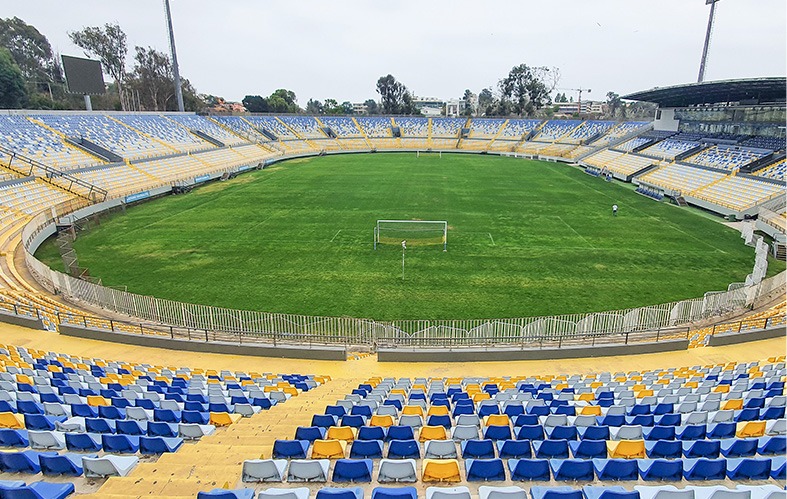On the image, a shot from one of the sides of the 
                            Sausalito Stadium is appreciated. There are stands of 
                            the color blue and yellow. In the middle is the football 
                            court.
