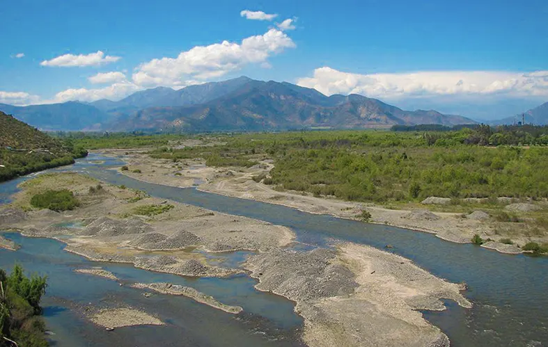 On the image, a frontal shot of the course of the 
                            Aconcagua river can be appreciated. There are 
                            meadows, and in the back is the Andes mountain range.